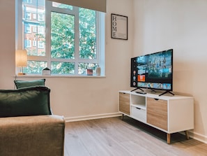 Relax in a peaceful urban setting with a view of tree-lined streets from the large window.