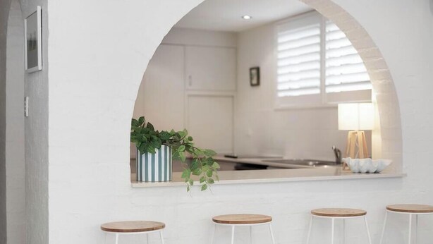 A modern kitchen with white cabinets, a large window, and a hanging plant. - Alice (Bayona 7) - Little Cove (Noosa Heads)