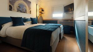A hotel room with a large bed, a desk, a TV, and a window. - Mia Hotels Fes (Fes)