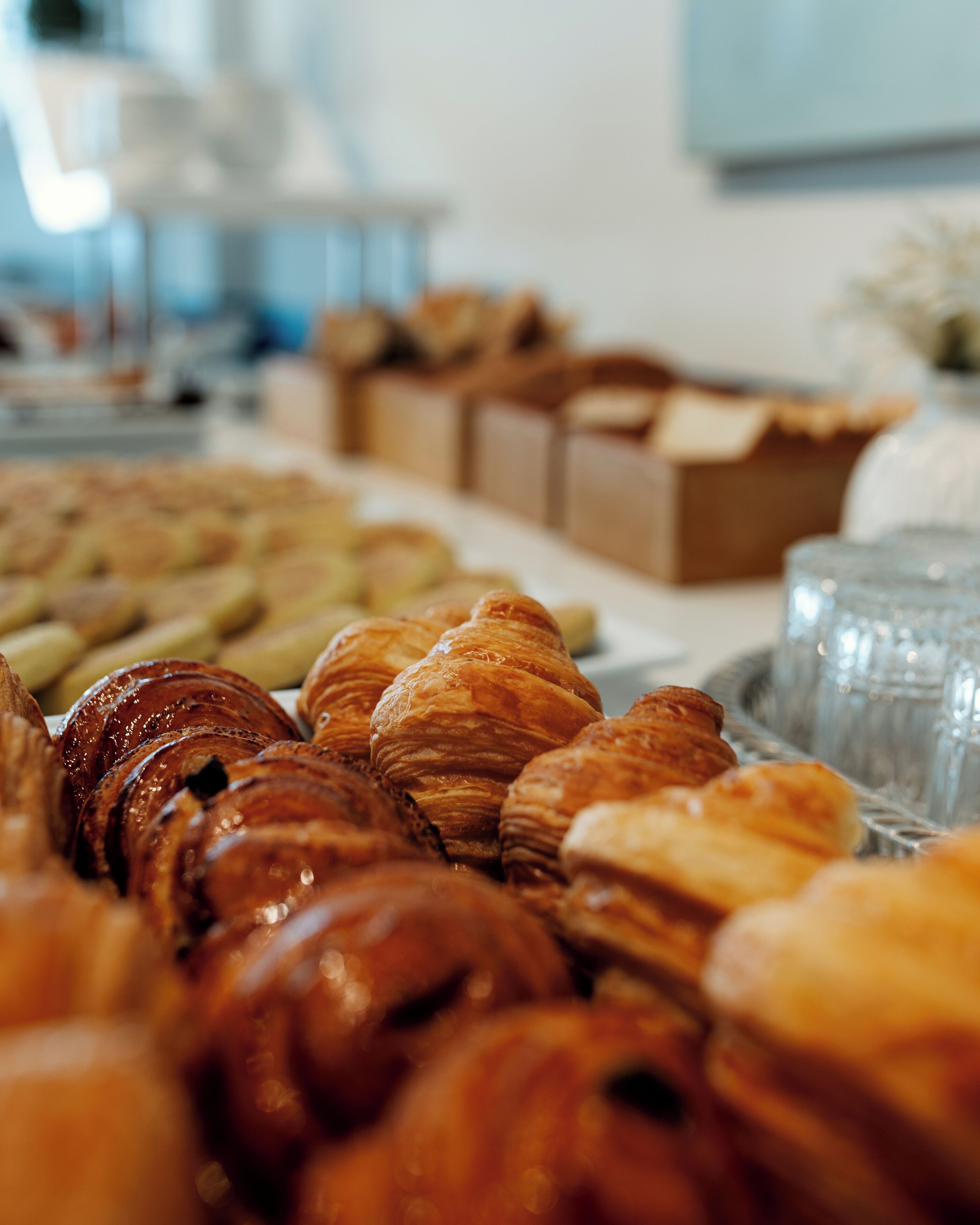 Una variedad de pasteles, incluyendo croissants y otras delicias horneadas, expuestos sobre una mesa.