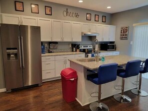 Enjoy cooking in this well-equipped kitchen with a central island and bar stools.