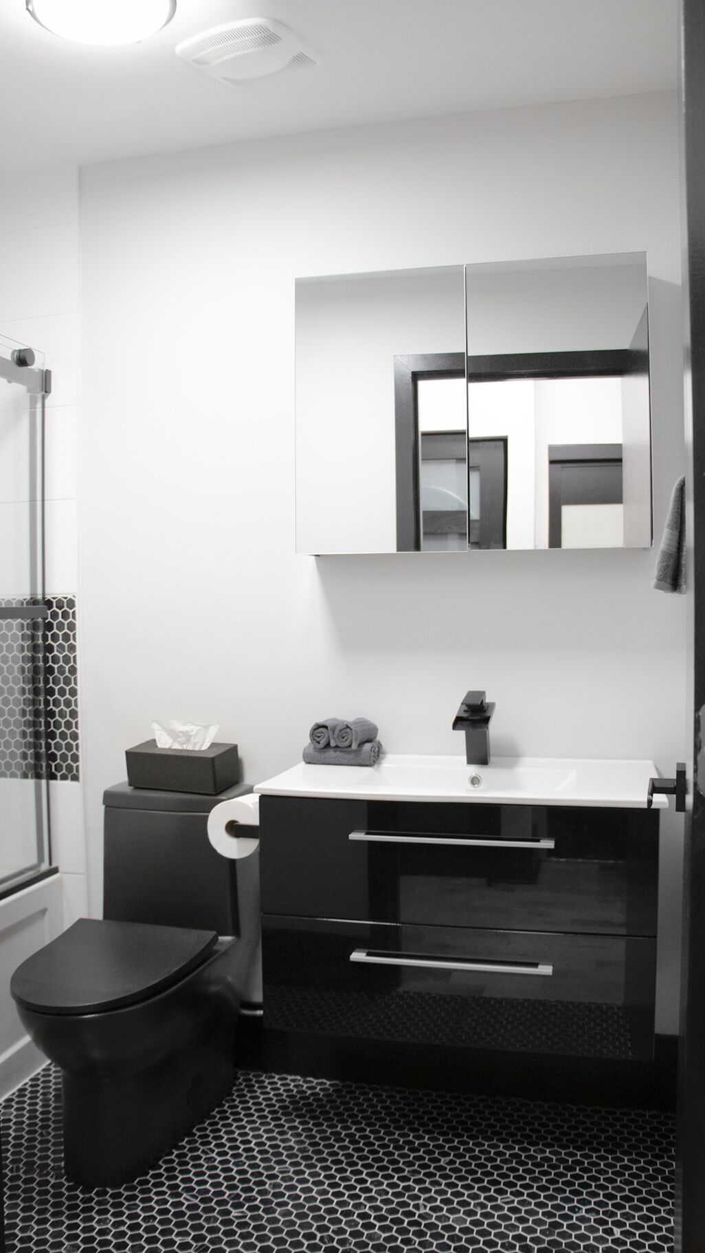 A modern bathroom with a toilet, sink, and shower.