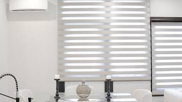 Une cuisine moderne équipée d’un lave-vaisselle, d’un évier et d’un robinet. Deux luminaires suspendus sont fixés au-dessus du plan de travail.