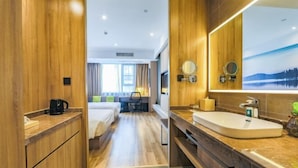 Une chambre d’hôtel avec un intérieur en bois, un grand lavabo et une vue sur un lac par la fenêtre.
