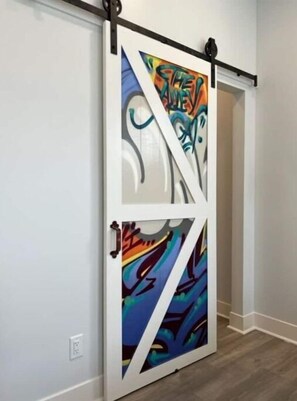 Unique graffiti door adds artistic flair to this stylish room.