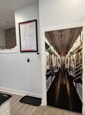 Enter a unique underground world through this subway-style door, flanked by a vintage map and a black doormat.