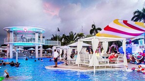 A pool area with a monkey-themed bar and lounge chairs under a striped canopy. - Playa Palmera Beach Resort  (Punta Cana)