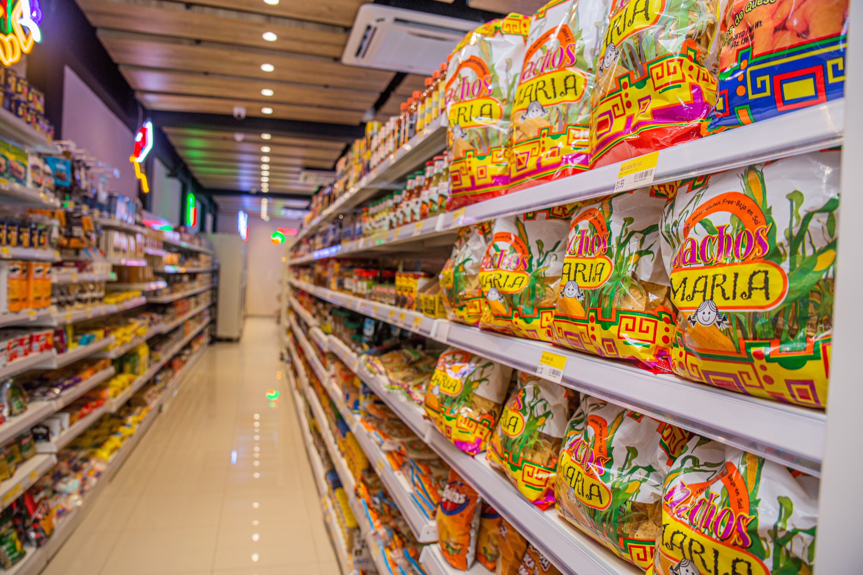 Een gangpad in een supermarkt met schappen vol snackverpakkingen.