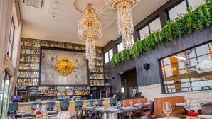A restaurant with a bar area, multiple dining tables, and a large chandelier. - Playa Palmera Beach Resort  (Punta Cana)