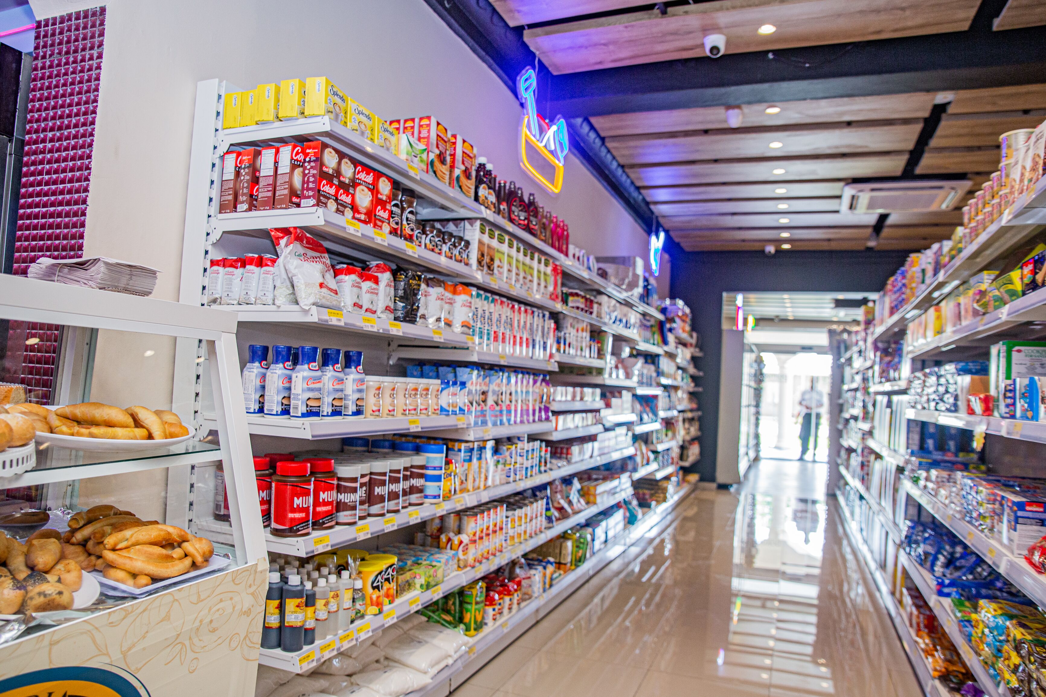 A grocery store aisle with shelves stocked with various food items and beverages.
