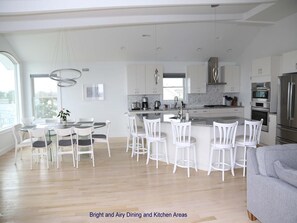 Enjoy meals in the kitchen and dining area with stainless steel appliances, white cabinetry, and a round table.