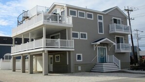 Un immeuble résidentiel à plusieurs étages, doté de balcons, d’un garage et d’une entrée principale.