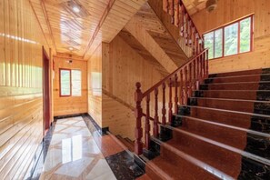 A wooden interior with a staircase and a polished floor. - Longji Rice Terraces Heshe Homestay (Longsheng)