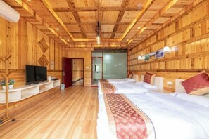 A wooden-paneled room with a bed, a TV, and a desk with a computer. - Longji Rice Terraces Heshe Homestay (Longsheng)