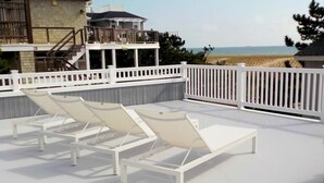 A rooftop deck with two white lounge chairs and a white railing. - OCEAN VIEWS! BEAUTIFUL HOME SLEEPS 14! (North Beach)