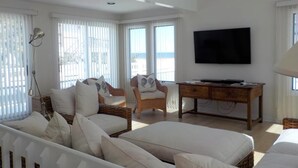 A spacious room with a large bed, a desk, and a television. - OCEAN VIEWS! BEAUTIFUL HOME SLEEPS 14! (North Beach)