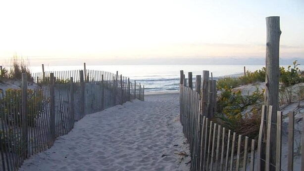 A sandy beach path with wooden fencing on both sides leading to the ocean. - Ship Bottom Ocean Block with Pool (Ship Bottom)