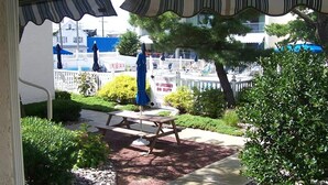 A covered patio with a picnic table and a sign that reads 'NO LIFEGUARD ON DUTY.' - Ship Bottom Ocean Block with Pool (Ship Bottom)