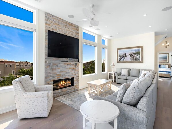 A spacious living room with a fireplace, a large TV, and a comfortable seating area.
