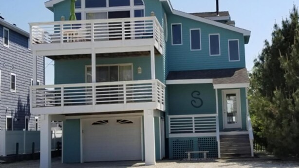 A two-story building with a balcony, a garage, and a letter 'S' on the facade. - 4 bedroom accommodation in Harvey Cedars (Harvey Cedars)