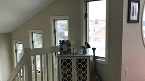A room with a staircase, a window with a view, and a small table with items on it. - 4 bedroom accommodation in Harvey Cedars (Harvey Cedars)