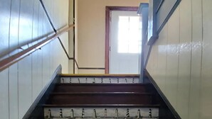 Eine hölzerne Treppe mit Geländer, die zu einer Tür führt.