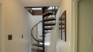 Eine Wendeltreppe mit Holzvertäfelung und einem Oberlicht darüber.