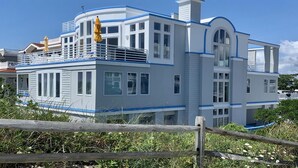 A large, modern house with multiple levels, large windows, and a prominent balcony. - Surf City Oceanfront With Panoramic Views (Surf City)