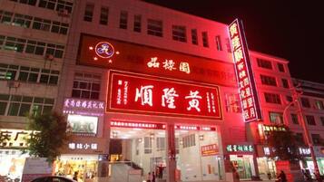 A building with illuminated signage, multiple entrances, and a visible storefront.