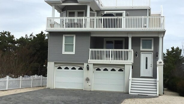 A two-story house with a balcony, two garages, and a front door. - 4 bedroom accommodation in Barnegat Light (Barnegat Light)