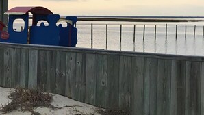 A wooden fence with a blue structure, possibly a boat, near a body of water. - 4 bedroom accommodation in Barnegat Light (Barnegat Light)
