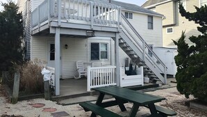 Une maison à deux étages dotée d’un balcon, d’un porche et d’un escalier menant à l’étage supérieur.