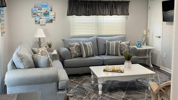 A living room with a sofa, coffee table, and a rug. - Ocean block duplex located in the heart of Surf City. (Surf City)