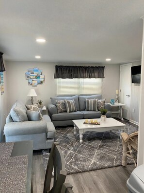 A living room with a sofa, coffee table, and a rug.