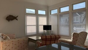 A room with a large window, a fish decoration, a television, and a dining table. - 3 BEDROOM IN DESIRABLE BEACH HAVEN (Beach Haven)