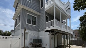 A two-story house with a balcony, a gravel driveway, and a white fence. - Amazing home in Beach Haven with 4 Bedrooms, Internet and WiFi (Beach Haven)
