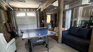A room with a ping pong table, a sofa, and a chair. - Amazing home in Beach Haven with 4 Bedrooms, Internet and WiFi (Beach Haven)