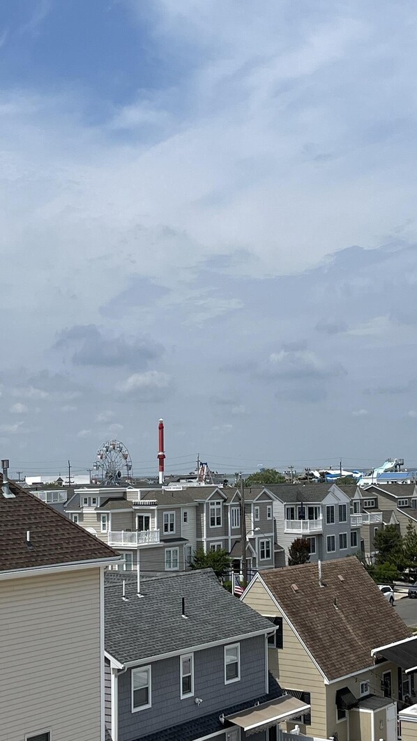 A residential area with houses, a Ferris wheel, and a lighthouse in the distance.