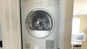 A stacked Bosch washer and dryer unit in a hallway. - LBI vacation rental property (Holgate)