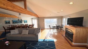A living room with a sofa, dining table, chairs, a TV, and a fireplace. - 5 BRs, Hot Tub Roof Top, 2nd off the Ocean. (Loveladies)