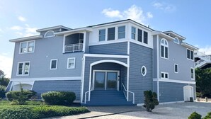 A two-story house with a balcony, a front door, and a garage. - 5 BRs, Hot Tub Roof Top, 2nd off the Ocean. (Loveladies)