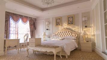 A classic bedroom with a large bed, bedside tables, a chair, and a patterned floor.