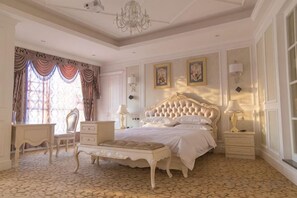 A classic bedroom with a large bed, bedside tables, a chair, and a patterned floor. - Impression Theme Hotel (Nan County)