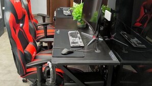 A gaming chair, a desk with a computer setup, and a monitor. - Impression Theme Hotel (Nan County)