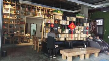 A bookstore with shelves of books, a black sofa, and a wooden bench.