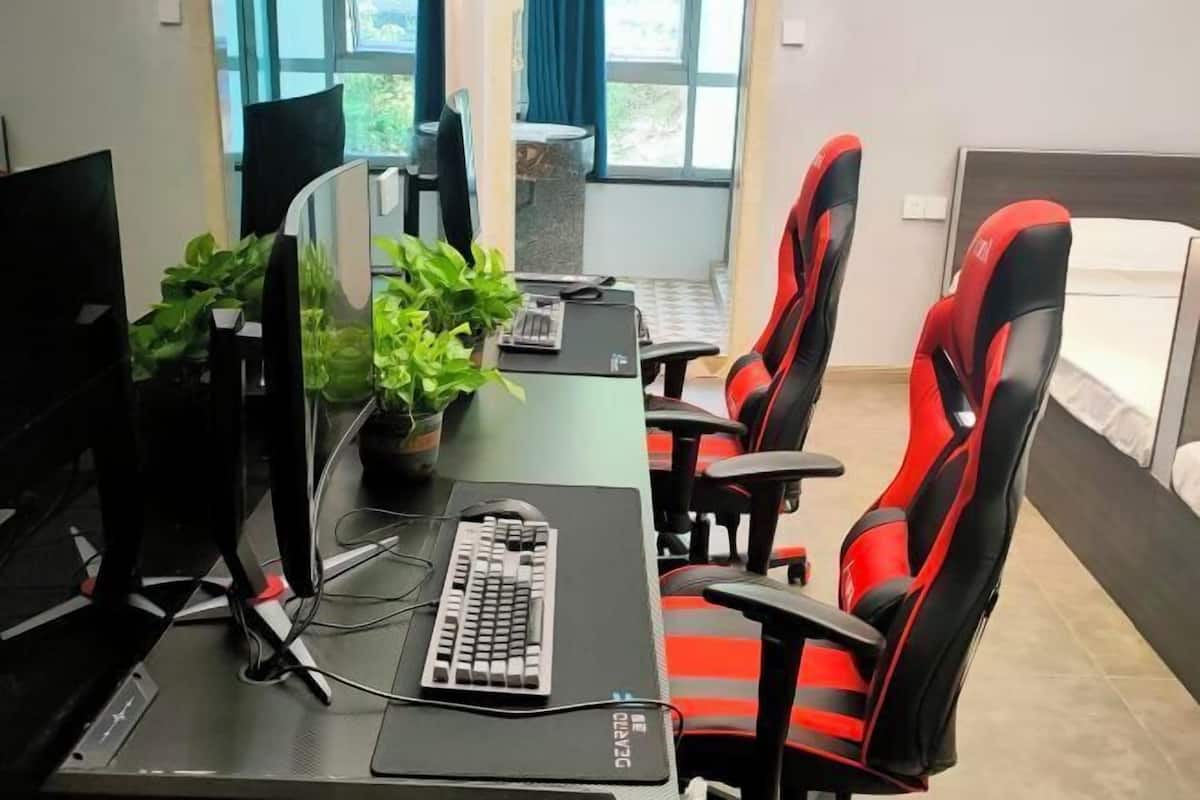 A modern office with a desk, computer, keyboard, and ergonomic chairs.