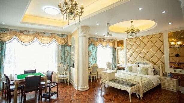 A spacious room with a large bed, a billiards table, and a chandelier. - Impression Theme Hotel (Nan County)