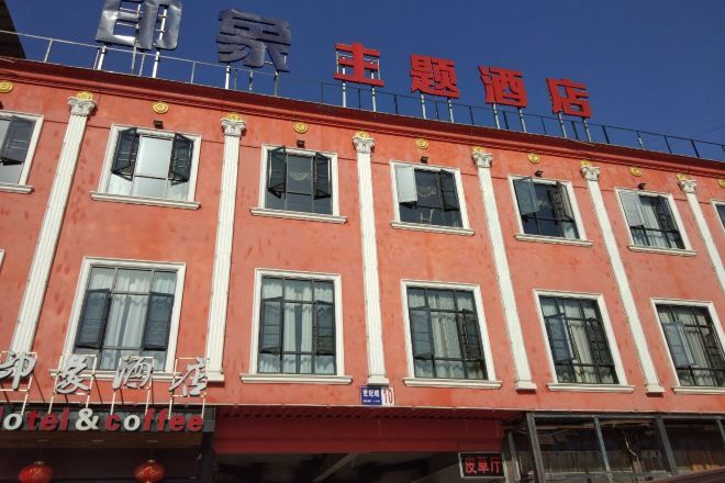 A hotel with a red facade, multiple windows, and a sign indicating a hotel and coffee shop.