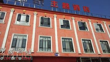 A hotel with a red facade, multiple windows, and a sign indicating a hotel and coffee shop.
