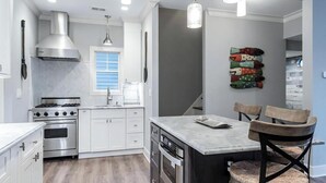 Een moderne keuken met roestvrijstalen apparatuur, een raam en decoratieve wanddecoratie van vissen.